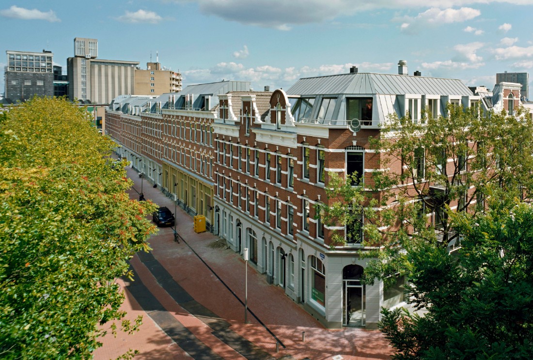 Foto van de gerenoveerde gevels en gebouwen aan het deliplein op de splitsing met de sumatraweg op katendrecht in rotterdam.