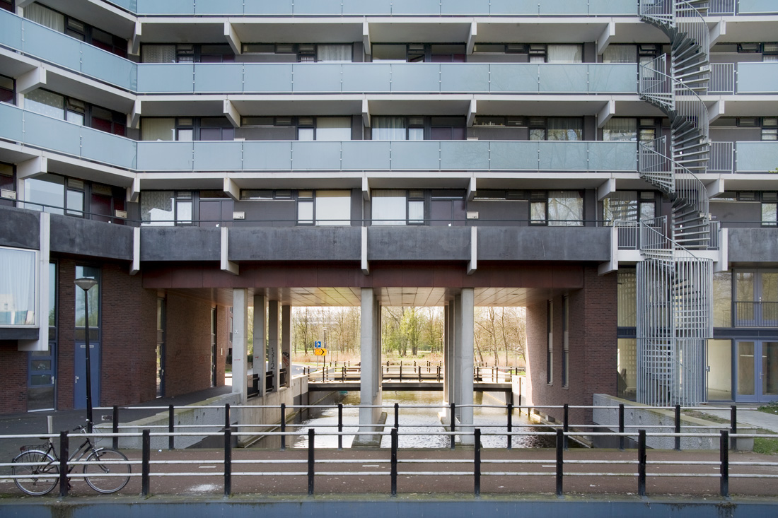 aangezicht van de plint van de gerenoveerde florijn waar een doorgang onder het gebouw is aangebracht met een watertje