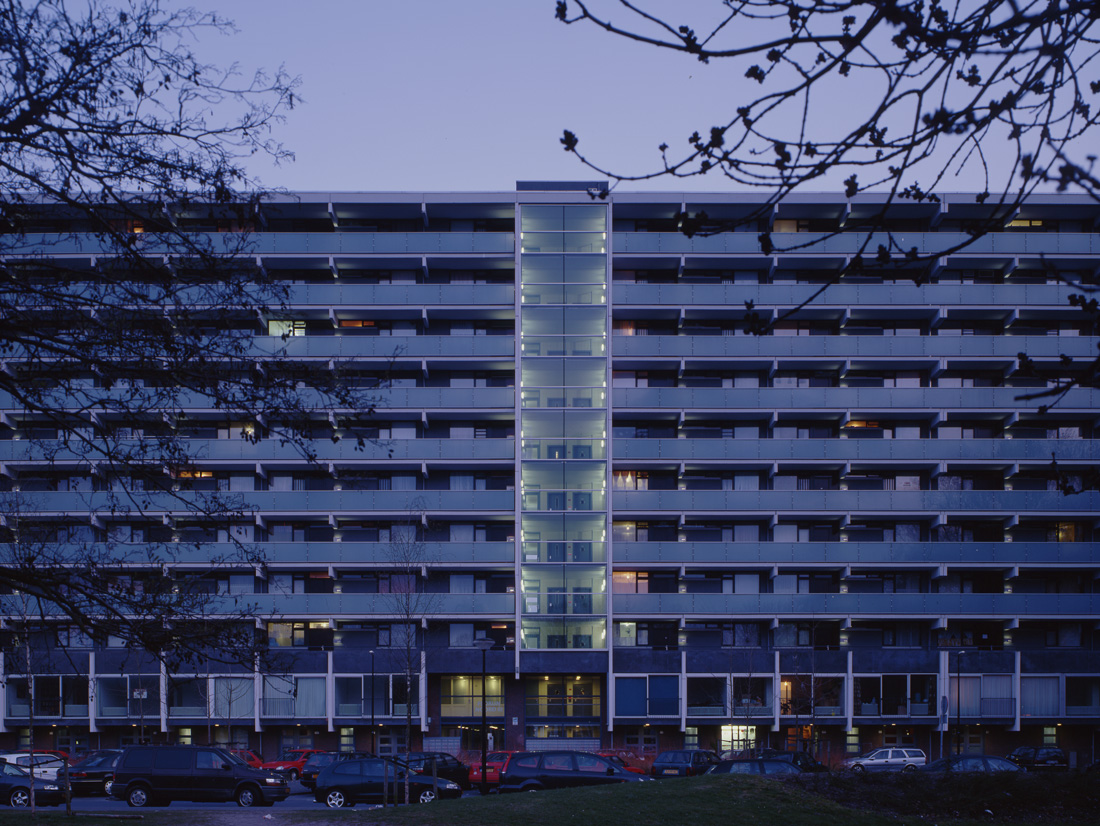 aanzicht van de florijn in bijlmermeer na de renovatie in de avond met auto's op de parkeerplaats ervoor