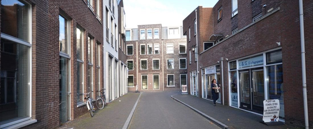 Corporatiehotel Hogewoerd in woerden gezoen vanuit de molenstraat met een voetganger op de rechter stoep