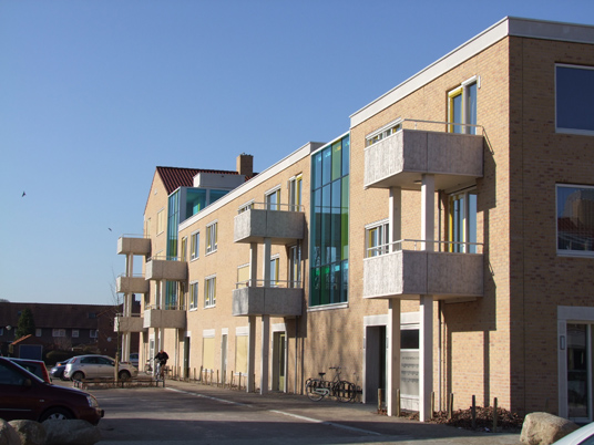 Zijaanzicht met uitstekende balkons van een van de gebouwen van de nieuwbouw in het schilderskwartier in woerden met gele en groene details