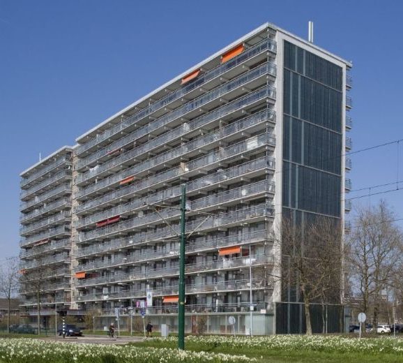 aanzicht van een van de prinsenflats in rijswijk in de nieuwe situatie na de renovatie met begroeiing en een tramlijn op de voorgrond