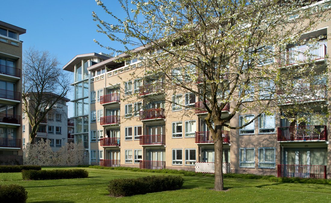 foto van de gerenoveerde dudokhaken aan de hof kant met gras en bomen ervoor