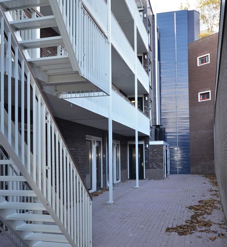 aanzicht van de binnenplaats met galerijen en trappen van het appartementencomplex hogewoerd in woerden