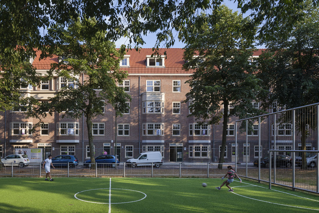 voetballende kinderen op een grasveldje voor de huizen aan de tugelaweg na de renovatie