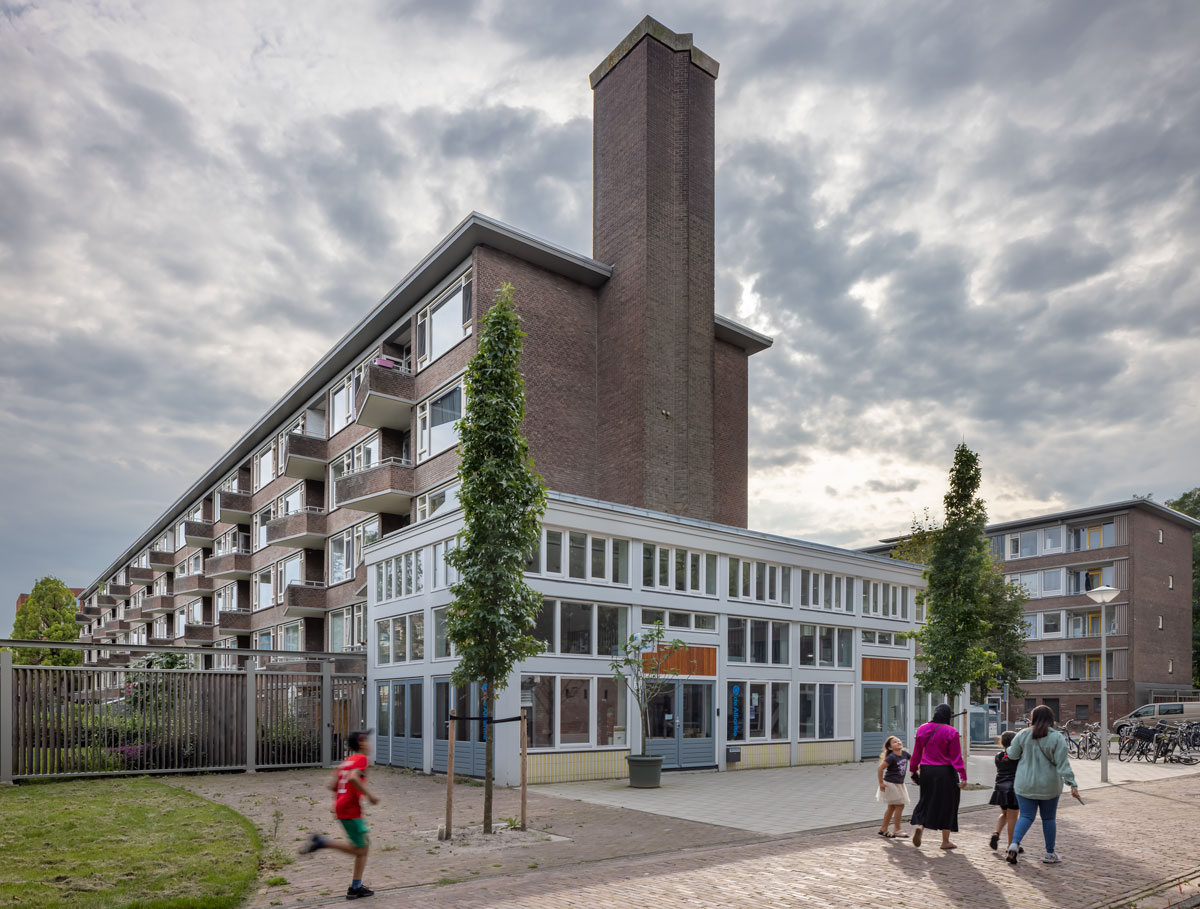 gerenoveerd ketelhuis met kenmerkende schoorsteen en verzinkt en gecoat stalen hek uit tijdelijke constructie